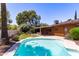 Sparkling backyard pool with ample patio space for relaxation, framed by mature trees and greenery at 3131 E Las Rocas Dr, Phoenix, AZ 85028