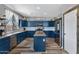 Well-lit kitchen features navy cabinetry, a center island, and modern stainless steel appliances at 32901 N Hidden Canyon Dr, San Tan Valley, AZ 85144