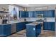 Well-lit kitchen with navy cabinets, white backsplash, stainless appliances, and bright window at 32901 N Hidden Canyon Dr, San Tan Valley, AZ 85144