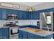 Close-up of kitchen with navy cabinets, modern appliances, and decorative countertops at 32901 N Hidden Canyon Dr, San Tan Valley, AZ 85144