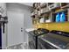 Well-organized laundry room with modern washer and dryer and custom wooden crate shelving at 32901 N Hidden Canyon Dr, San Tan Valley, AZ 85144