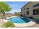 Beautiful in-ground pool with baja step, surrounded by desert landscaping and a wrought iron fence at 32901 N Hidden Canyon Dr, San Tan Valley, AZ 85144