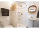Bright bathroom featuring a walk-in shower, pedestal sink, and round decorative mirror at 338 W Encanto Blvd, Phoenix, AZ 85003