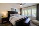Comfortable bedroom featuring a ceiling fan and a window with wooden shutters for natural light at 338 W Encanto Blvd, Phoenix, AZ 85003