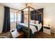 Spacious main bedroom features a four-poster bed, shuttered windows, and stylish décor at 338 W Encanto Blvd, Phoenix, AZ 85003