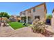 Backyard with artificial turf, desert landscaping, covered patio, and a basketball hoop for recreation at 3788 E Sexton St, Gilbert, AZ 85295
