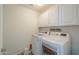 Laundry room features a white washer and dryer plus overhead cabinets at 3788 E Sexton St, Gilbert, AZ 85295