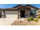 Attractive home exterior boasting stone accents, a covered entry, and a convenient two-car garage for ample parking at 4034 W Nora Dr, San Tan Valley, AZ 85144