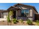 Inviting facade showcasing stone detailing, a covered porch, and manicured landscaping for enhanced curb appeal at 4034 W Nora Dr, San Tan Valley, AZ 85144