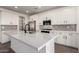 Modern kitchen featuring white cabinets, stainless steel appliances, and a large center island with a white countertop at 4034 W Nora Dr, San Tan Valley, AZ 85144