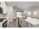 Bright kitchen with white cabinets, quartz countertops, stainless appliances, and an open floorplan with access to the patio at 4034 W Nora Dr, San Tan Valley, AZ 85144