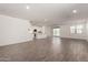 Expansive living room features wood-look flooring, a modern kitchen, and access to the backyard patio via sliding glass doors at 4034 W Nora Dr, San Tan Valley, AZ 85144