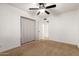 Simple carpeted bedroom featuring a ceiling fan and a partial window view at 4107 W Campo Bello Dr, Glendale, AZ 85308