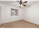 A carpeted bedroom with neutral walls, a ceiling fan, and a window view at 4107 W Campo Bello Dr, Glendale, AZ 85308