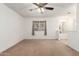 A bright carpeted bedroom with a ceiling fan and a bathroom entrance at 4107 W Campo Bello Dr, Glendale, AZ 85308