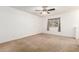 A simple carpeted bedroom featuring a ceiling fan and a window view at 4107 W Campo Bello Dr, Glendale, AZ 85308