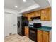 A kitchen featuring wood cabinetry, black appliances, and tile flooring at 4107 W Campo Bello Dr, Glendale, AZ 85308