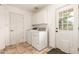 Well-lit laundry room with washer, dryer, white cabinets, and access door to outside at 4107 W Campo Bello Dr, Glendale, AZ 85308