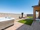 Backyard featuring a hot tub, artificial grass, and patio with a firepit at 41800 W Sonoran Trl, Maricopa, AZ 85138