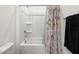 Bathroom features a tub and shower with a decorative shower curtain, and a towel rack at 41800 W Sonoran Trl, Maricopa, AZ 85138