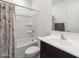 Bright bathroom featuring a tub with shower, dark vanity, and neutral walls at 41800 W Sonoran Trl, Maricopa, AZ 85138