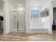 Bright bathroom featuring a soaking tub, walk-in glass shower, and wood-look tile flooring at 41800 W Sonoran Trl, Maricopa, AZ 85138