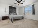 Bedroom with accent headboard, ceiling fan, bedside table, and a window at 41800 W Sonoran Trl, Maricopa, AZ 85138