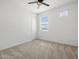 A serene bedroom features carpeted floors, a ceiling fan, and a bright window at 41800 W Sonoran Trl, Maricopa, AZ 85138