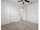 This bedroom is spacious and features two doors, a ceiling fan, and neutral carpet at 41800 W Sonoran Trl, Maricopa, AZ 85138