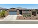 Single-story home with desert landscaping, gray garage door, and a stone accent wall under the window at 41800 W Sonoran Trl, Maricopa, AZ 85138