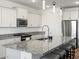 Modern kitchen with granite countertops, stainless steel appliances, and a kitchen island with bar seating at 41800 W Sonoran Trl, Maricopa, AZ 85138