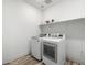 Well-lit laundry room equipped with modern washer and dryer units and a storage shelf at 41800 W Sonoran Trl, Maricopa, AZ 85138