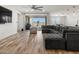 Open living space with wood-look floors and a large sectional sofa, leading to the backyard at 41800 W Sonoran Trl, Maricopa, AZ 85138