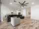 Open living space with wood-look floors and a large sectional sofa, adjacent to the kitchen at 41800 W Sonoran Trl, Maricopa, AZ 85138