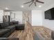 Bright living room featuring wood-look floors, a large sectional sofa and an open layout at 41800 W Sonoran Trl, Maricopa, AZ 85138