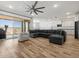Open living space with wood-look floors and a large sectional sofa, leading to the kitchen at 41800 W Sonoran Trl, Maricopa, AZ 85138