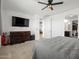 Spacious main bedroom featuring a large bed, dresser, TV, and a ceiling fan at 41800 W Sonoran Trl, Maricopa, AZ 85138