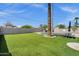 Large backyard featuring artificial turf, a sparkling pool, a hot tub, and a gray privacy wall at 4216 N 20Th St, Phoenix, AZ 85016