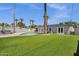 Lush backyard with artificial turf, a sparkling pool, a hot tub, and mature palm trees create a serene outdoor oasis at 4216 N 20Th St, Phoenix, AZ 85016