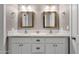 Bathroom featuring double sinks with granite countertops, mirrors, and white cabinets at 4216 N 20Th St, Phoenix, AZ 85016