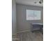 Bedroom featuring a desk and a window with blinds, set against neutral-colored walls and hardwood floors at 42435 W Desert Fairways Dr, Maricopa, AZ 85138