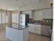 Bright kitchen featuring stainless steel appliances, granite countertops, and white cabinetry at 42435 W Desert Fairways Dr, Maricopa, AZ 85138