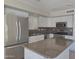 Updated kitchen with stainless steel appliances, granite countertops, and white cabinetry at 42435 W Desert Fairways Dr, Maricopa, AZ 85138