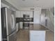 Updated kitchen with stainless steel appliances, granite countertops, and tile flooring at 42435 W Desert Fairways Dr, Maricopa, AZ 85138