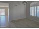 Inviting living room featuring carpet flooring, large windows, and sliding doors leading to the outdoors at 42435 W Desert Fairways Dr, Maricopa, AZ 85138