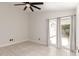 Bright bedroom featuring neutral paint, tile flooring, a ceiling fan, and access to the backyard at 4387 E Hartford Ave, Phoenix, AZ 85032