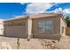 Home featuring a tile roof, tan stucco, a two-car garage, and desert landscaping at 4387 E Hartford Ave, Phoenix, AZ 85032