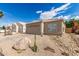 Home featuring a tile roof, tan stucco, a two-car garage, and desert landscaping at 4387 E Hartford Ave, Phoenix, AZ 85032