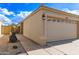 Home featuring a tile roof, tan stucco, two-car garage with low maintenance landscaping and gated access at 4387 E Hartford Ave, Phoenix, AZ 85032