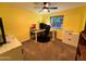 Home office with a window, yellow walls, ceiling fan, and computer on a desk at 4901 W Corrine Dr, Glendale, AZ 85304